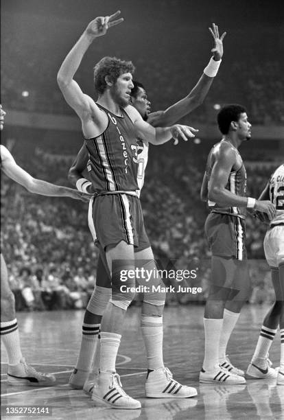 Portland Trail Blazers center Bill Walton, guarded by Nuggets center Marvin Webster, signals a play to his teammate during an NBA playoff game...