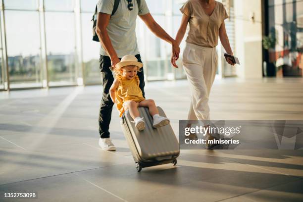 young family having fun traveling together - yellow suitcase stock pictures, royalty-free photos & images