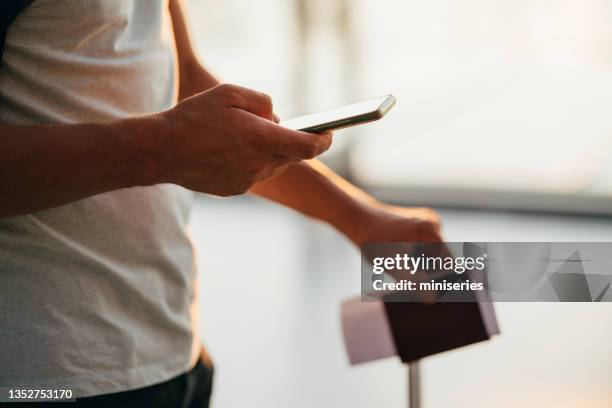 nahaufnahme foto von männlichen händen mit handy am flughafen - male airport stock-fotos und bilder