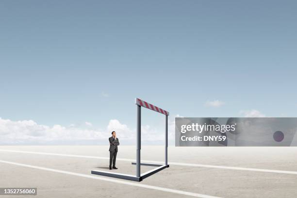 hombre de negocios mirando a hurdle frente a él - barrier fotografías e imágenes de stock