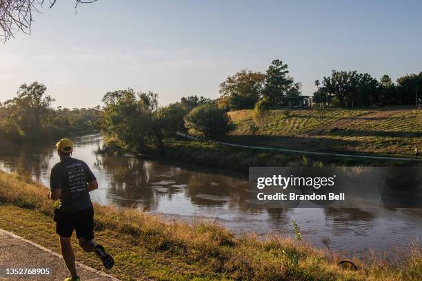 Person runs alongside the Buffalo Bayou on November 11, 2021 in Houston, Texas. The infrastructure legislation passed by Congress and awaiting...