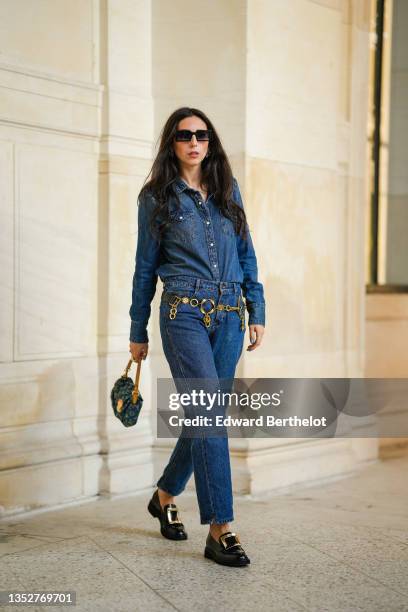 Gabriella Berdugo wears a blue denim shirt from Wrangler, matching blue denim jeans pants from Wrangler, a vintage golden chain belt, black leather...