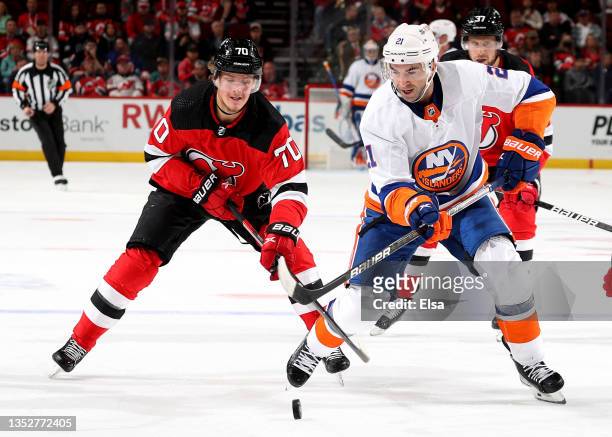 Kyle Palmieri of the New York Islanders takes the puck as Jesper Boqvist of the New Jersey Devils defends in the first period at Prudential Center on...