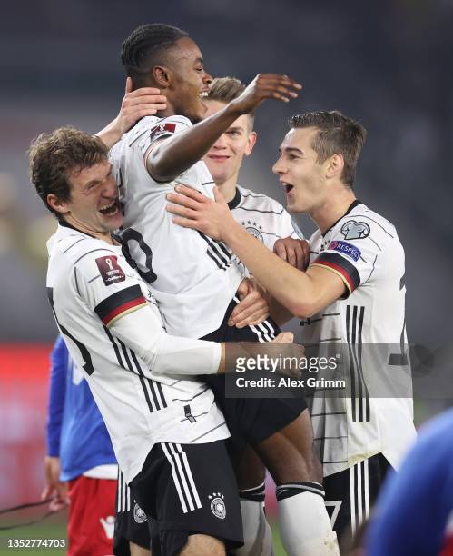 Ridle Baku of Germany celebrates his team's seventh goal with teammates Thomas Mueller and Florian Neuhaus during the 2022 FIFA World Cup Qualifier...