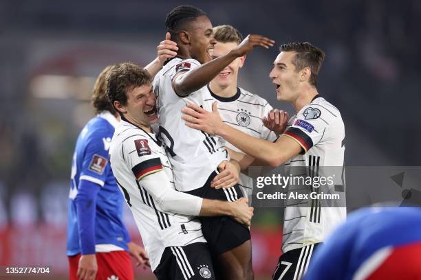 Ridle Baku of Germany celebrates his team's seventh goal with teammates Thomas Mueller and Florian Neuhaus during the 2022 FIFA World Cup Qualifier...