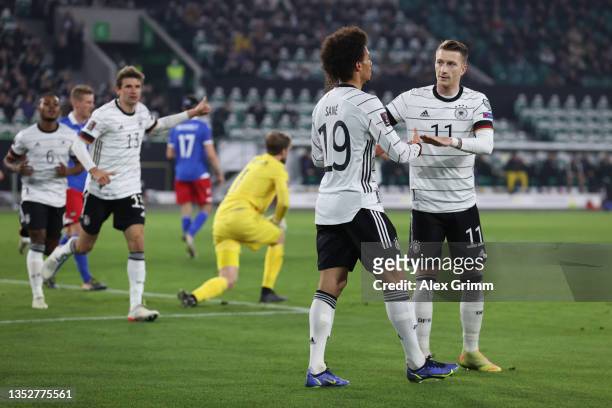 Leroy Sane of Germany celebrates his team's third goal with teammate Marco Reus during the 2022 FIFA World Cup Qualifier match between Germany and...