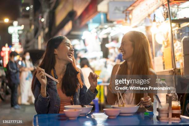 young female friends enjoying in night - cuisine thai ストックフォトと画像