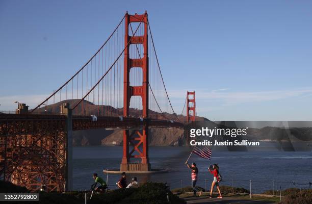 Protesters carry an American flag during an anti-vaccination rally at the Golden Gate Bridge on November 11, 2021 in San Francisco, California....