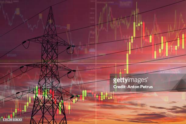 high voltage towers on the background of stock charts. electricity price change concept - consumerism foto e immagini stock