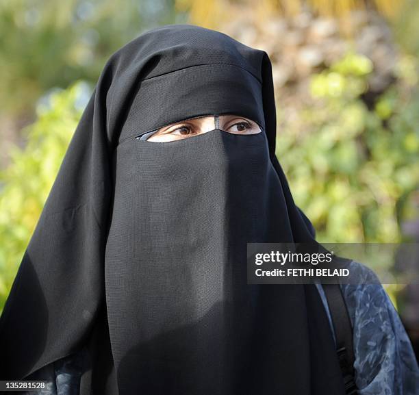 Female student, wearing a niqab, attends a demonstration outside the Faculty of Arts in Manuba, some 25 kms west of Tunis, on December 8, 2011....