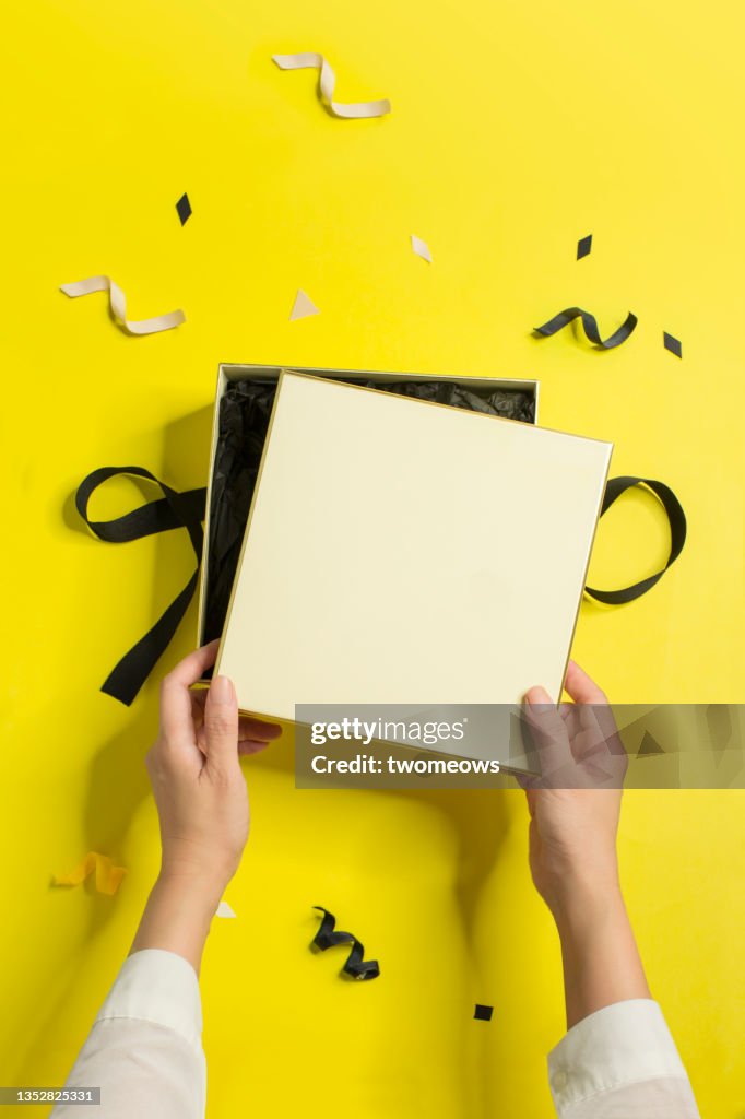 Yellow and black coloured gift boxes with hand still life.