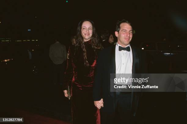 American actress Madeleine Stowe, wearing a red velvet dress, and her husband, American actor Brian Benben attend the 16th CableACE Awards, held at...