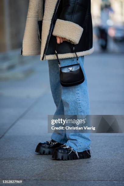 Alessa Winter is seen wearing shearling jacket, denim jeans, Miu Miu boots, Prada bag, Balenciaga sunglasses on November 11, 2021 in Berlin, Germany.