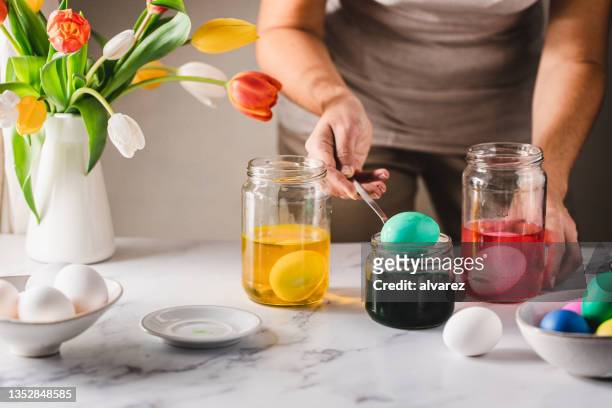 frau, die ostereier zu hause färbt - easter eggs stock-fotos und bilder