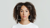 Biometric facial recognition of calm young african american female, isolate on gray background