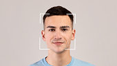 Smiling young caucasian male, double exposure with id scan, isolated on light background