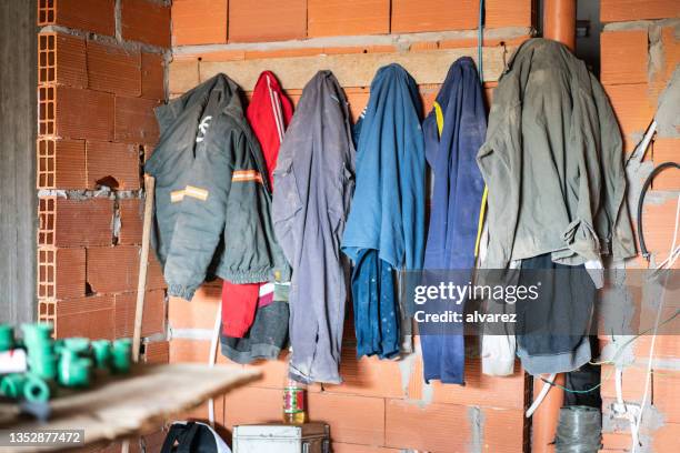 work clothes hanging  at construction site - locker room wall stock pictures, royalty-free photos & images