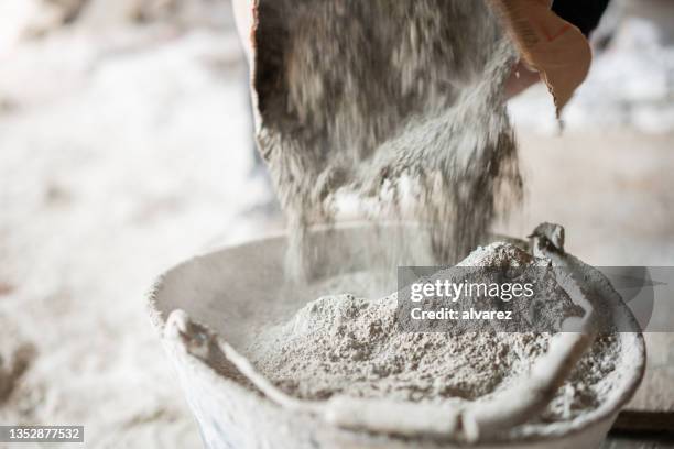 filling a bucket with cement at construstion site - concrete building stockfoto's en -beelden