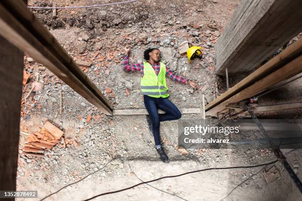 construction worker accident lying unconscious on building site - injured at work stock pictures, royalty-free photos & images