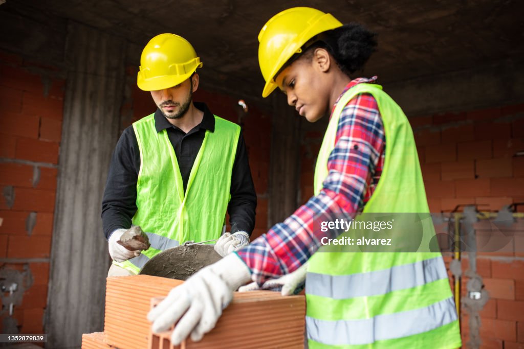 Two mason workers working at construction site