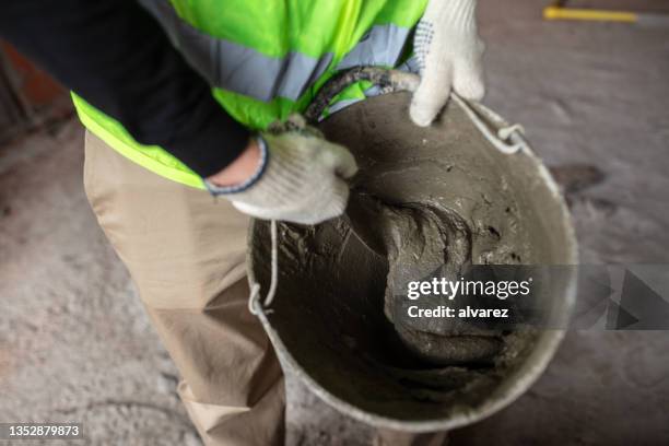 bauarbeiter mörtel in eimer auf der baustelle - kombination stock-fotos und bilder