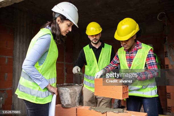 engineer supervisor the bricklaying working at construction site - female bricklayer stock pictures, royalty-free photos & images