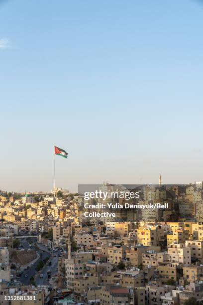 jordan's flag is waving in the distance across the skyline of amman, jordan - amman skyline stock pictures, royalty-free photos & images