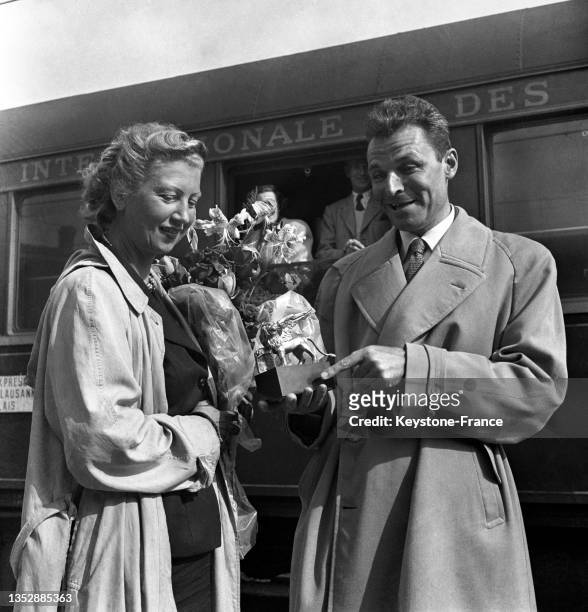 André Cayatte présentant son 'Lion d'or' à son épouse lors de son retour de la biennale de Venise, le 16 septembre 1950, à Paris.