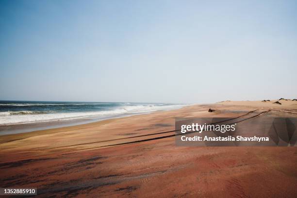 paysage aride pittoresque avec plage de sable minéral rouge et océan en namibie - désert du namib photos et images de collection