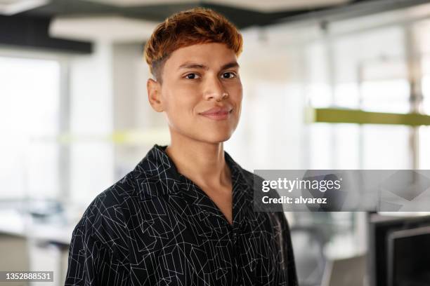 portrait of a young confident man standing in office - hipster guy stock pictures, royalty-free photos & images