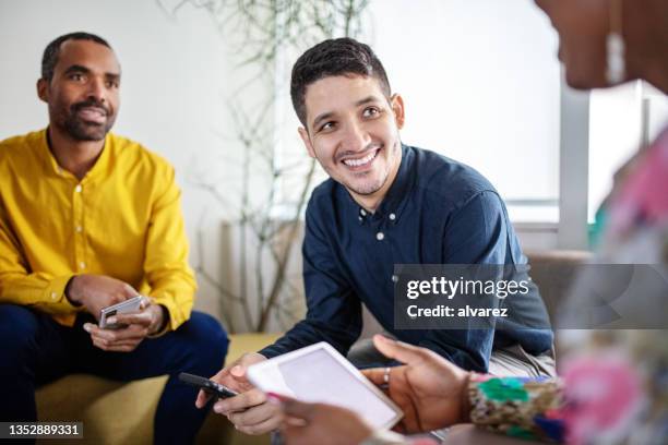 young man in meeting with colleagues at office lobby - social media marketing stock pictures, royalty-free photos & images