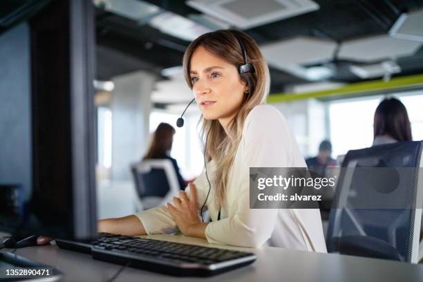 kundendienstmitarbeiter, der am computer im büro arbeitet - customer relationship management stock-fotos und bilder