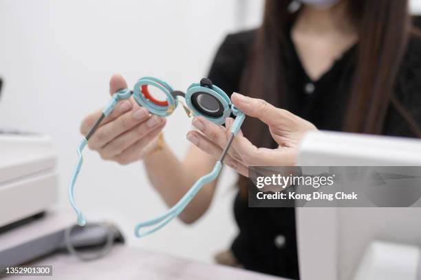 une ophtalmologiste chinoise asiatique choisit des lentilles pour la monture d’essai - eye test equipment stock photos et images de collection