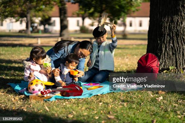 eine junge familie beim picknicken und spielen - baby spielt mit essen stock-fotos und bilder