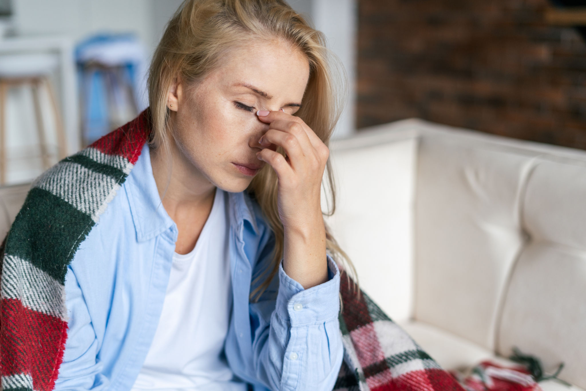 Tired woman with closed eyes touching nose bridge Tired woman with closed eyes touching nose bridge