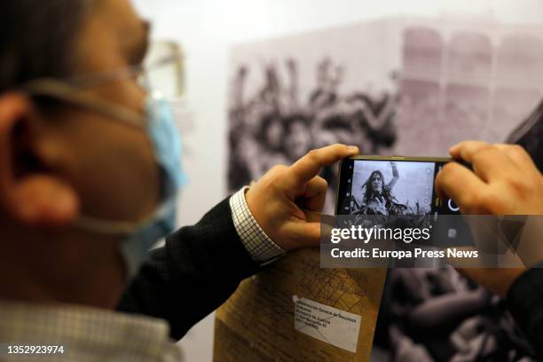 Man photographs one of the posters of the exhibition Madrid Metal, at the CentroCentro space, on November 14 in Madrid, Spain. Madrid Metal wants to...