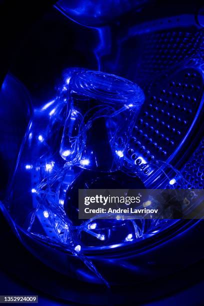 a bottle of cognac in blue garland lights. gift for new year and christmas. - antique washing machine stock pictures, royalty-free photos & images
