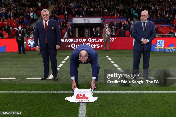 Sir Geoff Hurst MBE lays a shirt with '49' printed on in memory of Ronald Flowers MBE prior to the 2022 FIFA World Cup Qualifier match between...