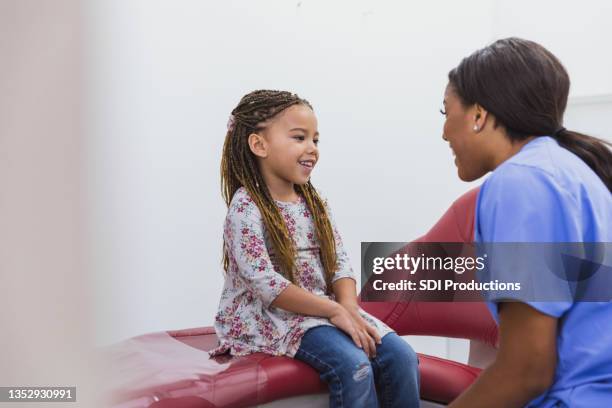 dental hygienist talks with young pediatric patient - cute nurses stockfoto's en -beelden