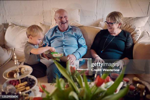 grand parents in sofa - echt gezin stockfoto's en -beelden