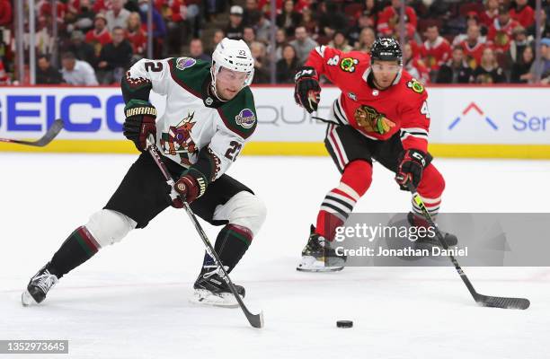 Johan Larsson of the Arizona Coyotes advances the puck against Seth Jones of the Chicago Blackhawks at the United Center on November 12, 2021 in...