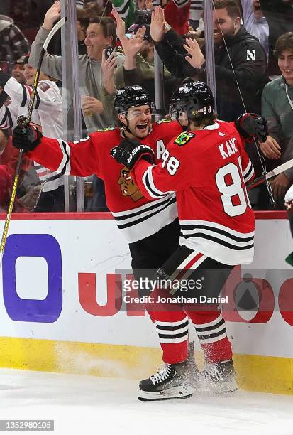 Alex DeBrincat of the Chicago Blackhawks celebrates scoring a second period goal with Patrick Kane against the Arizona Coyotes at the United Center...