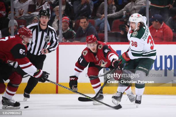 Mats Zuccarello of the Minnesota Wild passes the puck pressured by Dysin Mayo of the Arizona Coyotes during the NHL game at Gila River Arena on...