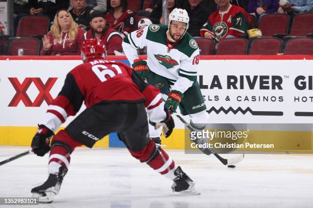 Jordan Greenway of the Minnesota Wild skates with the puck against Dysin Mayo of the Arizona Coyotes during the NHL game at Gila River Arena on...