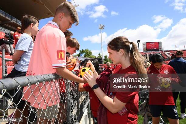 Players sign autographs after a joint A-League United A-League Men's & Women's team training session at Coopers Stadium on November 13, 2021 in...