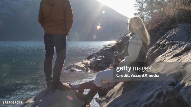 couple enjoy hot beverage on a mountain lake at sunrise - sun flare couple stockfoto's en -beelden