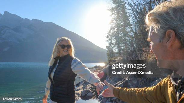 couple explore  a mountain lake at sunrise - sun flare couple stockfoto's en -beelden