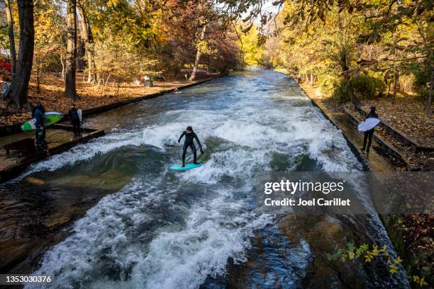 surfing on the eisbach river in munich, germany - munich autumn stock pictures, royalty-free photos & images