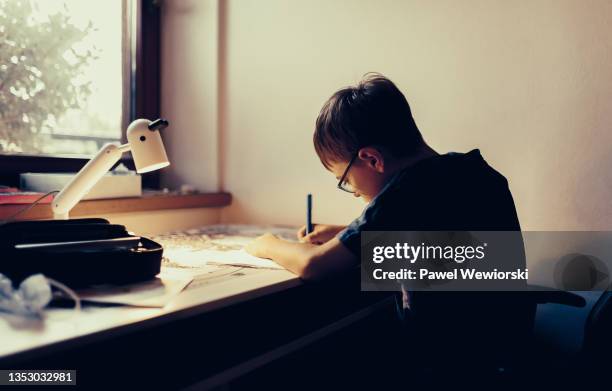 boy doing homework - desk lamp fotografías e imágenes de stock