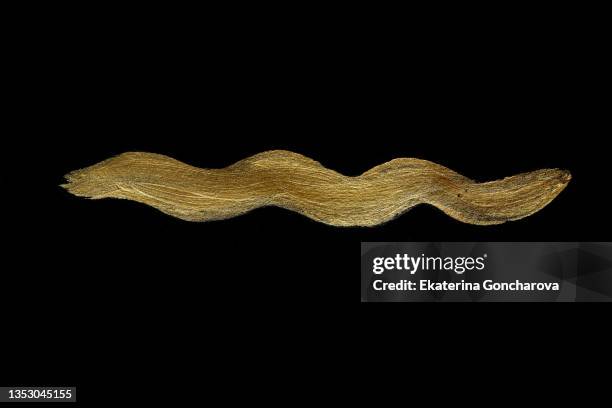 a beautiful smear of gold paint in the form of a plaque on a black isolated background. - gold plaque stock-fotos und bilder